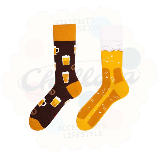 Chaussettes fantaisie dépareillées motif bière : une chaussette marron avec chopes de bière et bretzels, l’autre jaune avec bulles et mousse blanche façon verre de bière rempli.