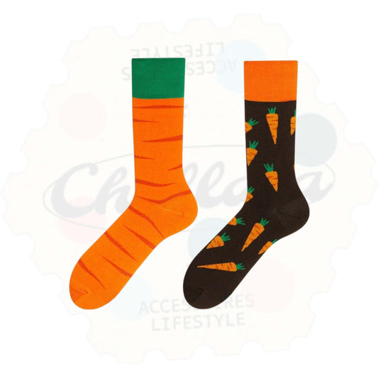 Chaussettes fantaisie dépareillées motif carotte : une chaussette orange avec rayures façon peau de carotte et bout vert, l’autre noire avec des carottes orange et vertes répétées.