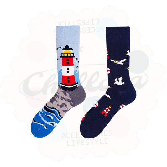 Chaussettes fantaisie dépareillées style marin inspiration Bretagne : une chaussette avec un phare rouge et blanc sur fond océan, l’autre avec des mouettes blanches et petits phares sur fond bleu marine.